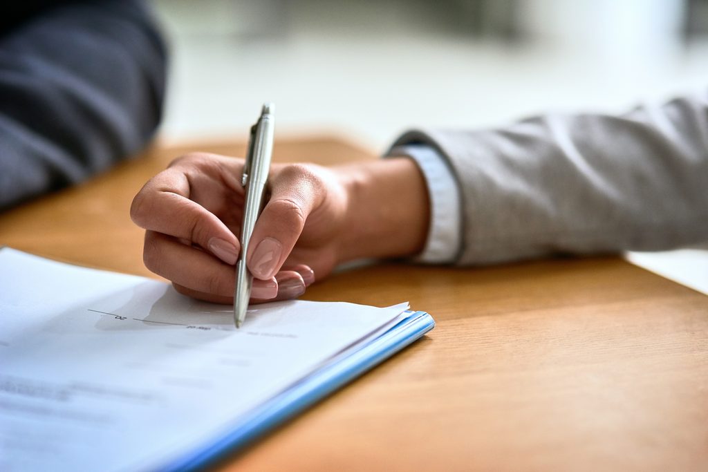 Mulher assinando declaração de doação para OSC em escritório