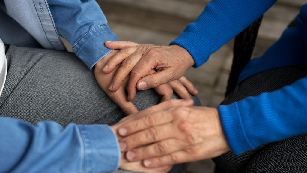 O que é o SUAS: profissional segura as mãos de uma pessoa atendida em um gesto de acolhimento e apoio